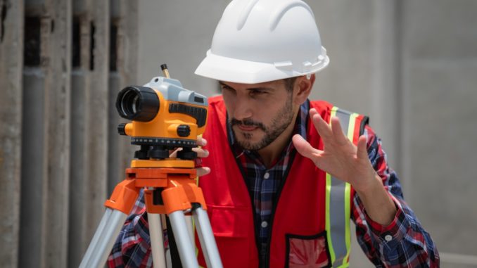 Civil or construction engineer using a survey camera, or an engineer with an auto level camera.